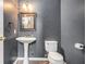Bathroom featuring a pedestal sink, mirror, and toilet, complete with neutral paint and hardwood floors at 175 Fenwyck Commons, Fayetteville, GA 30214