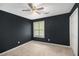 Bedroom with dark walls, carpeted floor, ceiling fan, and natural light from the window at 175 Fenwyck Commons, Fayetteville, GA 30214