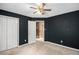 Dark-walled bedroom featuring carpeted floors, ceiling fan, and a doorway to another room at 175 Fenwyck Commons, Fayetteville, GA 30214