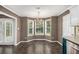 Bright breakfast nook with hardwood floors, chandelier, and a bay window with views of the green yard at 175 Fenwyck Commons, Fayetteville, GA 30214