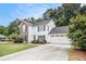 View of a two-story home with blue shutters, an attached garage, and green lawn at 175 Fenwyck Commons, Fayetteville, GA 30214