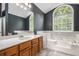 Bathroom showcasing a tub, walk-in shower, large window, and oak cabinets at 175 Fenwyck Commons, Fayetteville, GA 30214