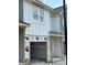 A modern, new construction townhouse showing the front exterior with covered garage at 29 Benscot Dr, Austell, GA 30106