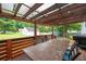 Outdoor deck features a dining table and chairs with a wood pergola and string lights at 701 Rockingham Ct, Woodstock, GA 30189