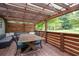 Covered deck with a dining table, cushioned seating, and wood railing at 701 Rockingham Ct, Woodstock, GA 30189