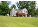 Two-story home featuring a lush green lawn, a charming wooden deck, and mature trees at 701 Rockingham Ct, Woodstock, GA 30189