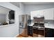 Renovated kitchen with stainless steel refrigerator and oven/range, and view to the living room at 701 Rockingham Ct, Woodstock, GA 30189