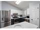 Updated kitchen features stainless steel appliances, white upper cabinets, and black lower cabinets at 701 Rockingham Ct, Woodstock, GA 30189