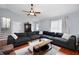 Cozy living room with hardwood floors, a ceiling fan, and a large, comfortable sectional sofa at 701 Rockingham Ct, Woodstock, GA 30189