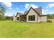 Spacious backyard featuring a well-maintained lawn and modern home exterior with black window trim at 210 Regester Way, Peachtree City, GA 30269