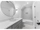 Bathroom features a modern vanity with a sleek countertop and a large, round mirror at 210 Regester Way, Peachtree City, GA 30269