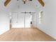 Open bedroom featuring wood floors, a vaulted ceiling, and a modern barn door at 210 Regester Way, Peachtree City, GA 30269