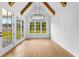 Dining room with wooden beams, modern light fixture, three large windows, and access to the outside at 210 Regester Way, Peachtree City, GA 30269