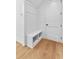 Mudroom features a built in bench seat and storage nook with coat hooks, next to an entry door at 210 Regester Way, Peachtree City, GA 30269