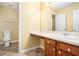 Bathroom featuring a toilet, a vanity with a sink, and a large mirror for convenience at 7492 Ferrara Dr, Lithonia, GA 30058