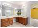 Bright bathroom features a double sink vanity with attractive wood cabinets and a decorative flower arrangement at 7492 Ferrara Dr, Lithonia, GA 30058