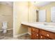 A well-lit bathroom with a modern toilet, sink, and a vanity offers a blend of comfort and modern style at 7492 Ferrara Dr, Lithonia, GA 30058