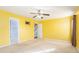 Bright yellow bedroom featuring carpet flooring, ceiling fan, and ample natural light at 7492 Ferrara Dr, Lithonia, GA 30058