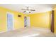 Yellow bedroom with carpeted floors, ceiling fan and 2 doors at 7492 Ferrara Dr, Lithonia, GA 30058
