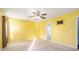 Bedroom with bright yellow walls, neutral carpet, ceiling fan, and a door to the bathroom at 7492 Ferrara Dr, Lithonia, GA 30058