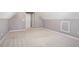 An upstairs bonus room or bedroom features neutral decor and sloped ceilings at 7492 Ferrara Dr, Lithonia, GA 30058