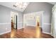Open dining area with hardwood floors, chandelier, neutral paint, and staircase views at 7492 Ferrara Dr, Lithonia, GA 30058