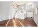 A spacious open floor plan features hardwood floors and a staircase with white banisters at 7492 Ferrara Dr, Lithonia, GA 30058