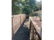 A narrow view of the backyard featuring a brick and stone retaining wall next to a tall wooden fence at 140 Puckett Creek Dr, Canton, GA 30114