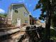 View of the green home featuring a stone retaining wall and a backyard with an outdoor deck at 140 Puckett Creek Dr, Canton, GA 30114