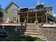 A two-story home showing off its backyard features a raised deck and beautifully terraced landscaping at 140 Puckett Creek Dr, Canton, GA 30114