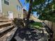 Beautiful green home has backyard featuring stone retaining wall, wood piles, and privacy fence at 140 Puckett Creek Dr, Canton, GA 30114