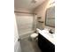 Neutral bathroom with a black vanity, grey tile flooring, and a shower-tub combination with glass door at 140 Puckett Creek Dr, Canton, GA 30114