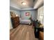 Blue bedroom with a vintage bed, wood-look floors, desk, and a sliding barn door at 140 Puckett Creek Dr, Canton, GA 30114