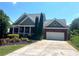 Charming single Gathering home featuring a two-car garage and a lush, landscaped front yard at 140 Puckett Creek Dr, Canton, GA 30114