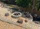 A stone fire pit in the backyard is surrounded by comfortable log seating and pea gravel at 140 Puckett Creek Dr, Canton, GA 30114