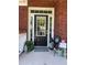Inviting front porch with a stylish black door and decorative plants at 140 Puckett Creek Dr, Canton, GA 30114