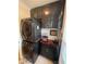 A well-organized laundry room with a modern stacked washer and dryer unit and custom upper and lower cabinets at 140 Puckett Creek Dr, Canton, GA 30114