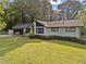 Exterior view of a cozy, one-story home with a lush green lawn and mature trees at 1759 Kimberly Sw Dr, Marietta, GA 30008