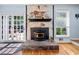 Stone fireplace with black mantle and hearth, complemented by hardwood floors and natural light from nearby windows at 1759 Kimberly Sw Dr, Marietta, GA 30008