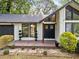 Inviting home exterior with a covered porch, well-maintained landscaping, and an attached garage at 1759 Kimberly Sw Dr, Marietta, GA 30008