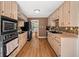 Functional kitchen with light wood cabinetry, tiled backsplash, and black appliances, offering a practical cooking space at 1759 Kimberly Sw Dr, Marietta, GA 30008