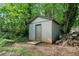 Backyard shed nestled amongst mature trees provides extra storage at 1759 Kimberly Sw Dr, Marietta, GA 30008