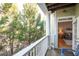 Balcony overlooking trees with blue Adirondack chairs and view of living room at 1975 Nocturne Dr # 2303, Alpharetta, GA 30009
