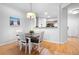 Dining area adjacent to the kitchen, featuring hardwood floors, a modern light fixture, and neutral wall colors at 1975 Nocturne Dr # 2303, Alpharetta, GA 30009