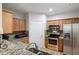 Kitchen area featuring stainless steel appliances, granite countertops, wood cabinets, and updated fixtures at 1975 Nocturne Dr # 2303, Alpharetta, GA 30009