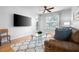 Cozy living room featuring hardwood floors, a large TV, a modern ceiling fan, and an outdoor patio at 1975 Nocturne Dr # 2303, Alpharetta, GA 30009