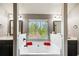 Bathroom featuring a soaking tub with black cabinets and a window view of the outdoors at 7933 Heathmore Dr, Fairburn, GA 30213