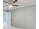 Bedroom featuring neutral carpet, a ceiling fan, and a closet with double doors at 7933 Heathmore Dr, Fairburn, GA 30213