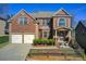 Charming two-story brick home with a two-car garage, landscaped yard, and a welcoming front porch at 7933 Heathmore Dr, Fairburn, GA 30213