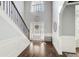 Bright foyer featuring hardwood floors, a staircase with elegant railings, and a transom window above the front door at 7933 Heathmore Dr, Fairburn, GA 30213